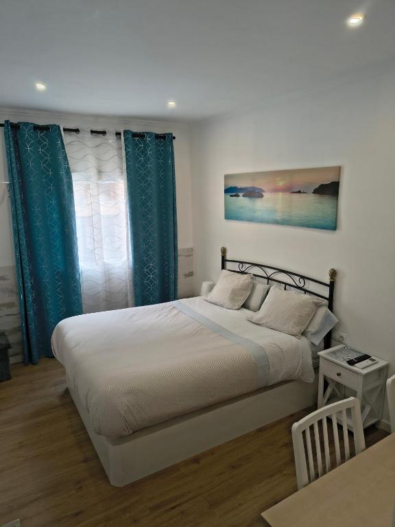 a bedroom with a large bed with blue curtains at AEROPUERTO BARCELONA -Mi colibrí in El Prat de Llobregat
