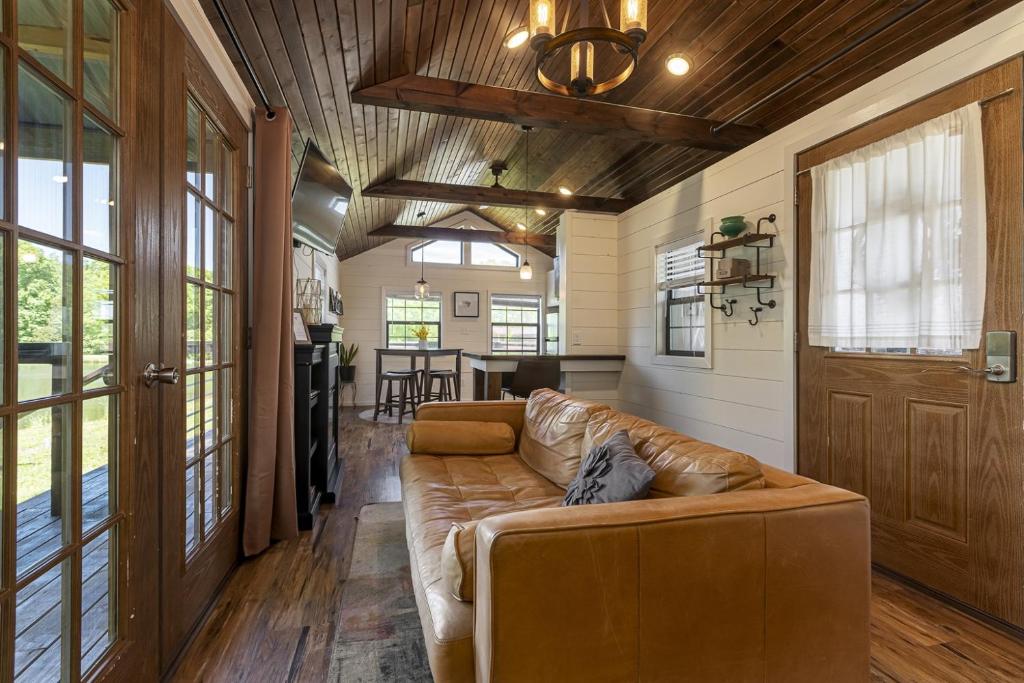 a living room with a brown leather couch in a house at Modern Pond-View Cabin Near Lake of Egypt in Marion