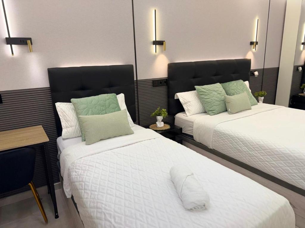 a bedroom with two beds and a table and a desk at Ap Fuenlabrada in Fuenlabrada