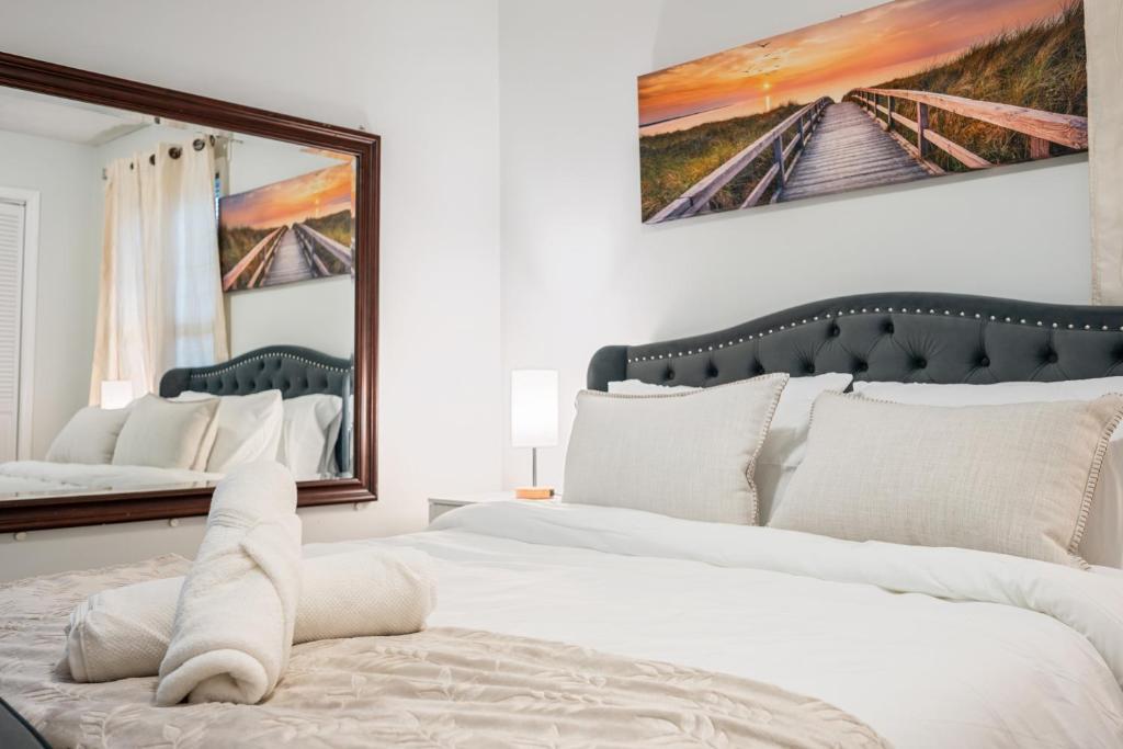 a bedroom with a large white bed with two mirrors at Charming Boston Retreat 3BR Parking Perfect for Families & Groups in Revere