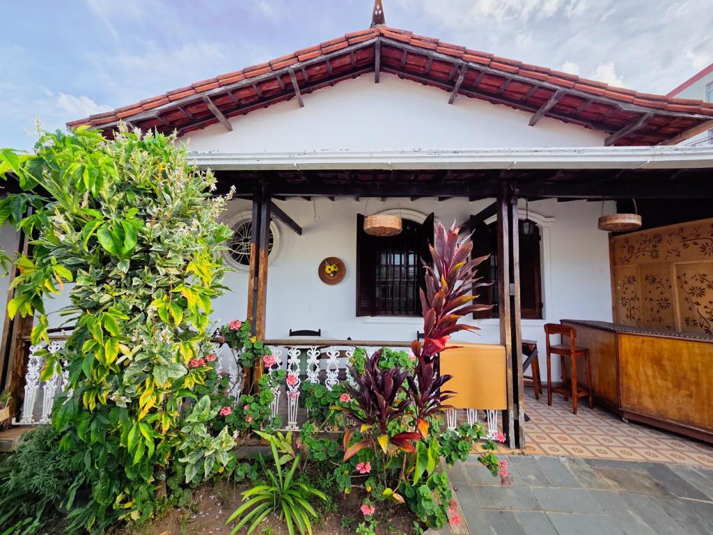 a white house with some plants in front of it at Vila Mariah Hostel in Belo Horizonte