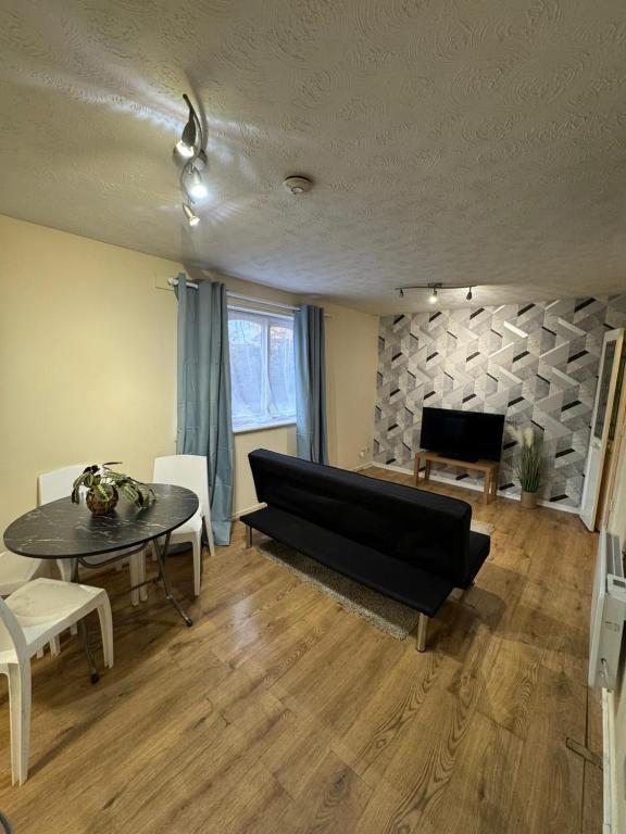 a living room with a couch and a table at Tranquil 1BD in Edmonton in Ponders End