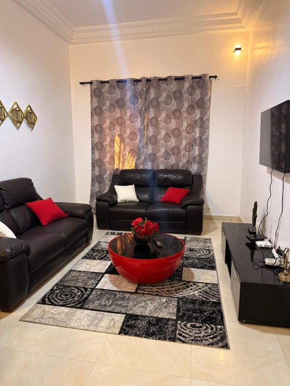 a living room with a black couch and a red bowl at Charmant Studio in Dakar