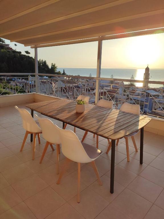 a wooden table and chairs on a patio at Stargaze Apartment with Sea View by MindYourVilla in Zakynthos