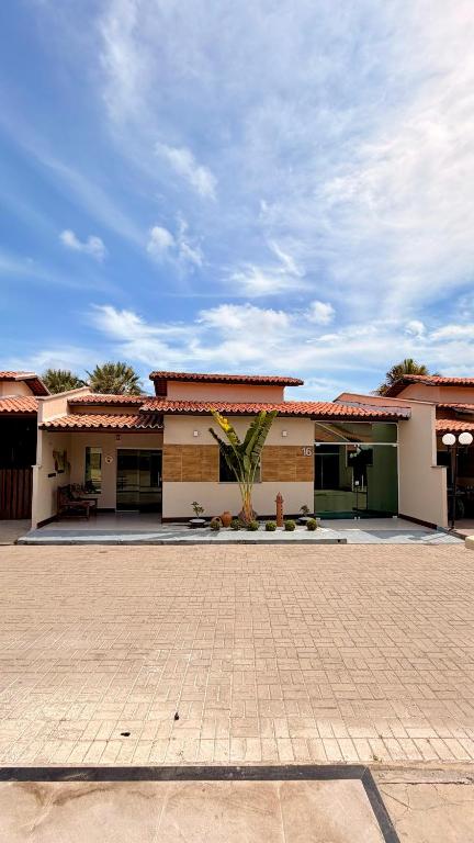 a building with a palm tree in front of it at Casabela - Summer Ville - Lençóis Maranhenses in Barreirinhas