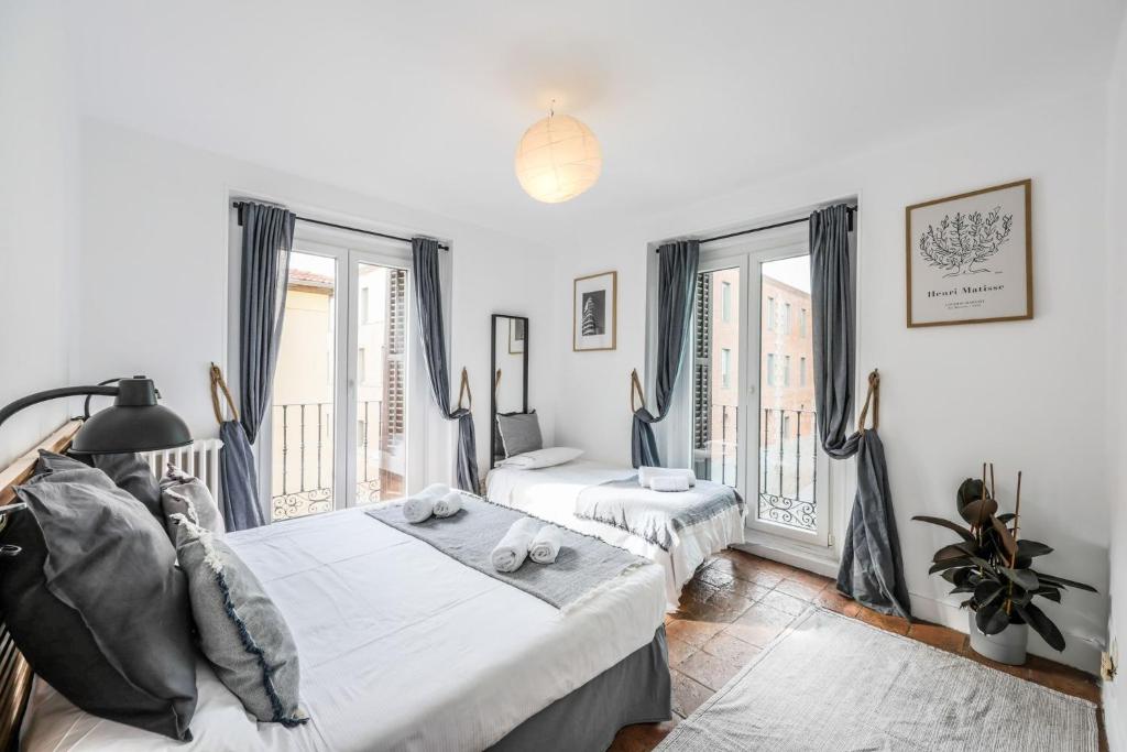 a bedroom with a bed and two windows at Agora Boutique Coliving Madrid in Madrid