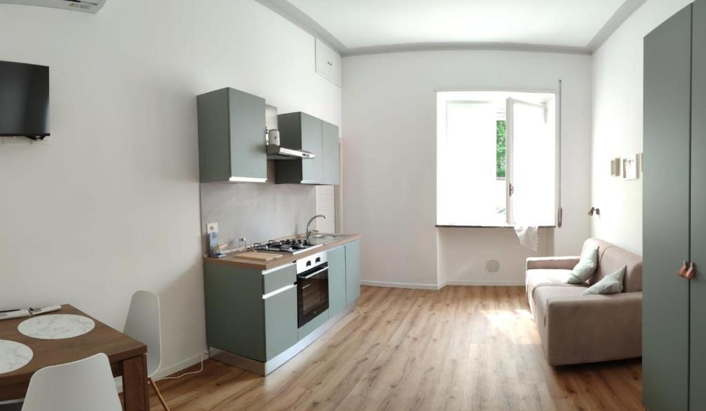 a kitchen with green cabinets and a living room at Casa Dante 4 in Pavia