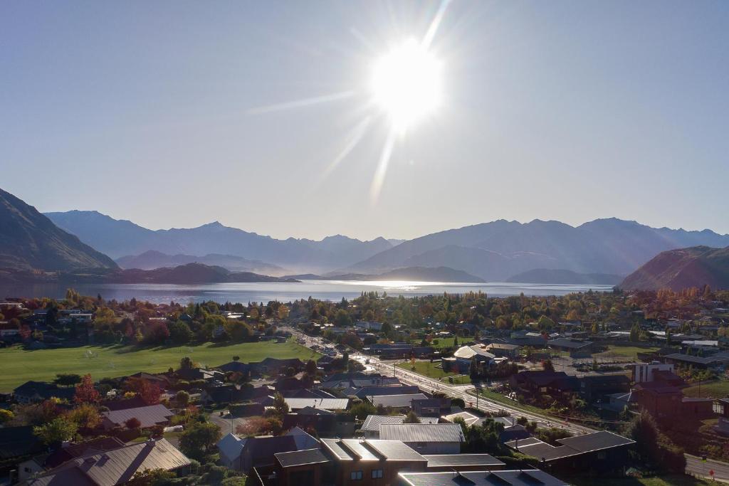 a view of a town with the sun in the sky at McNeil Luxury Studio in Wanaka