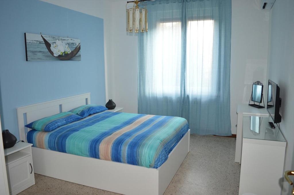 a blue bedroom with a bed and a television at Cologno Centro Apartment in Cologno Monzese