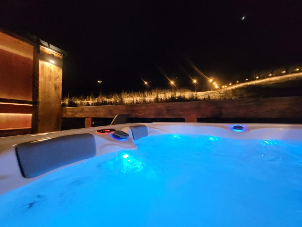 a jacuzzi tub at night with a view at Chalets Jasná Centrum APT KROWKA - Free Jacuzzi & Sauna and Chopok view in Belá