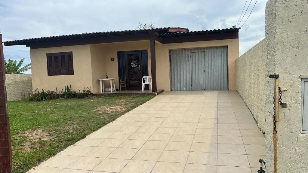 a small house with a garage and two chairs at Casa do Igra in Torres