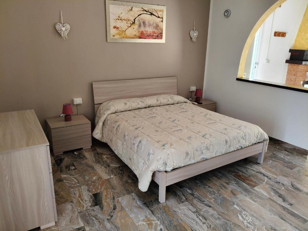a bedroom with a bed and two tables and a window at B&B SunBeach in San Benedetto del Tronto
