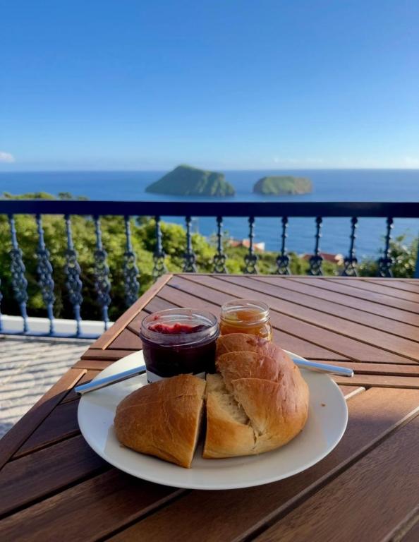 a plate of food with bread and jam on a table at Island View Retreat in Feteira