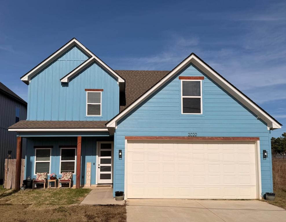 a blue house with a white garage at Wanderlust House in Shreveport
