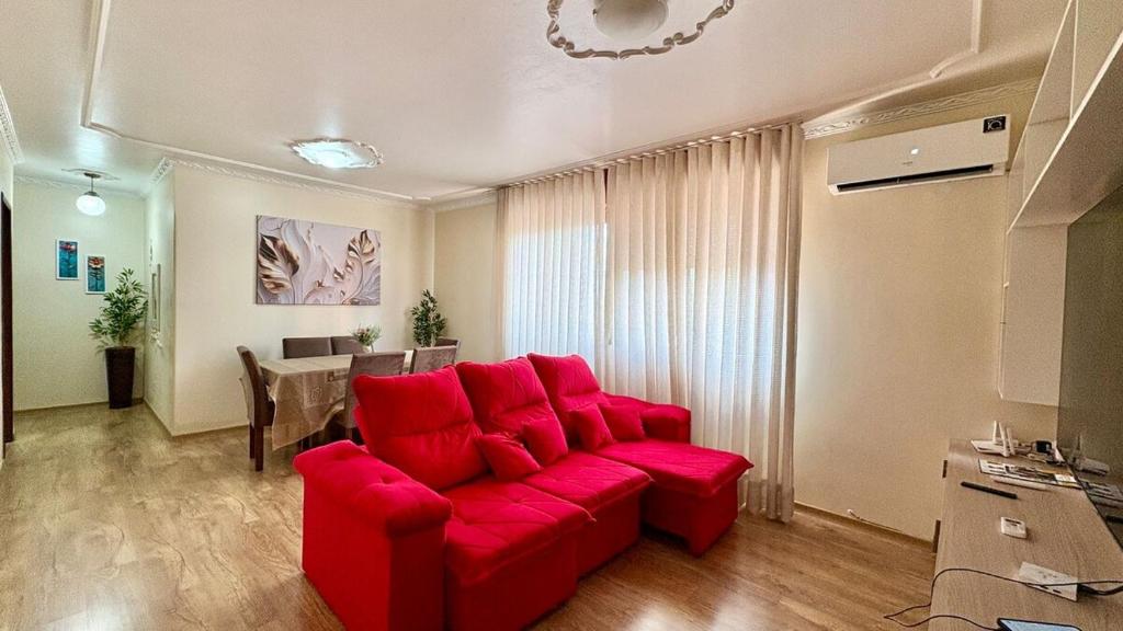 a red couch in a living room with a table at 3D apartment, central - prox UFN in Santa Maria