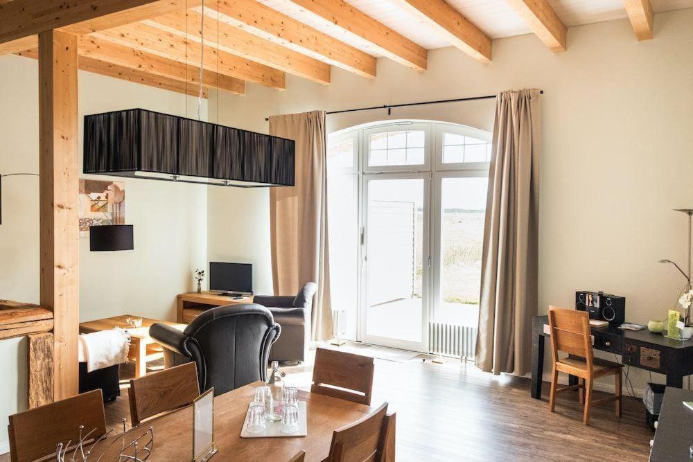 a living room with a table and a dining room at Gut-Royum-Strohlager in Brodersby
