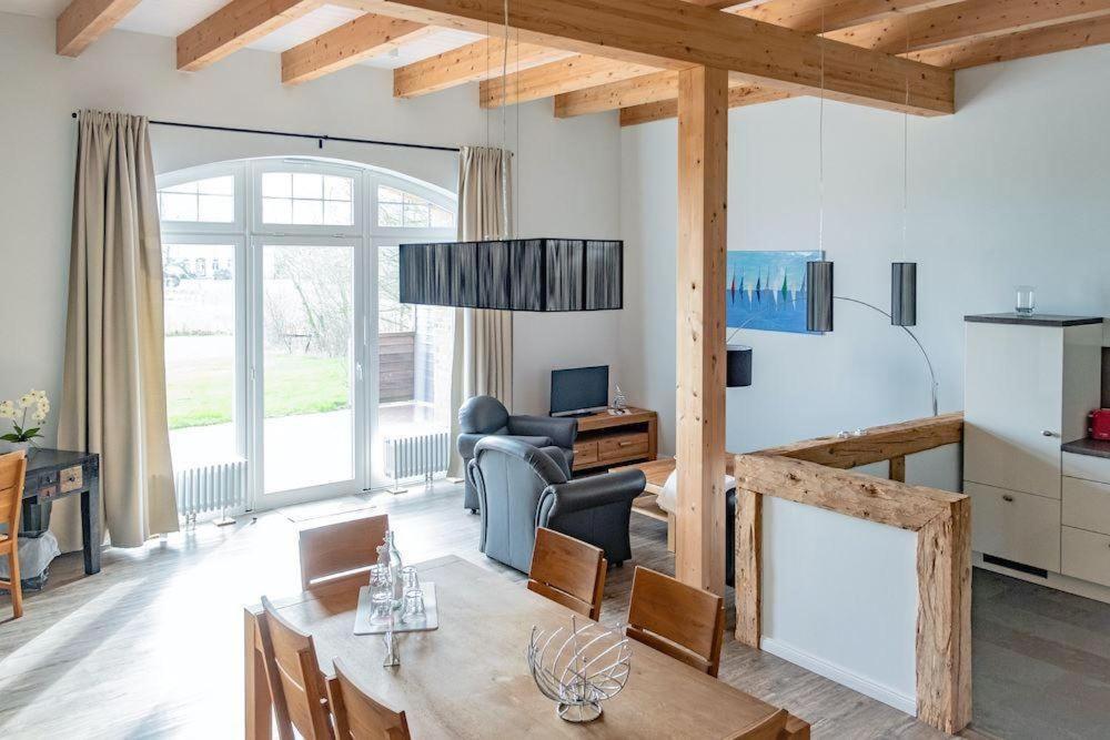 a living room with a table and a dining room at Gut-Royum-Haferkiste in Brodersby