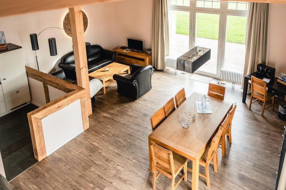 a living room with a table and chairs and a couch at Gut-Royum-Grosse-Diele in Brodersby