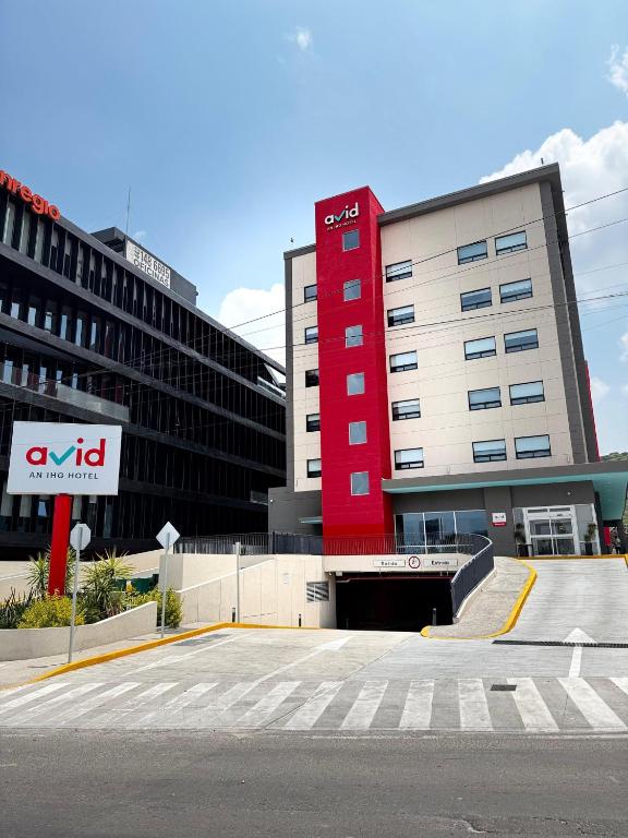 a red building in front of a building at Avid Hotel Querétaro Centro Sur by IHG in Querétaro