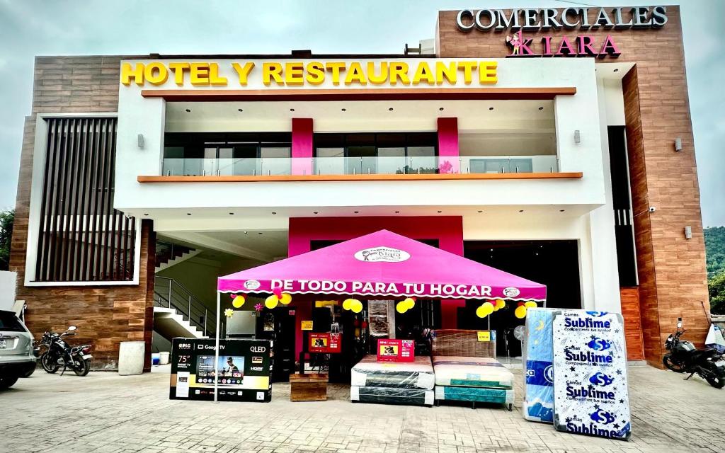 a store with a pink umbrella in front of a building at Hotel Kiara in Cataltzul