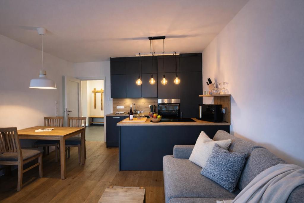 a living room and kitchen with a couch and a table at Die Malerei Penthouse by Da Alois in Gröbming