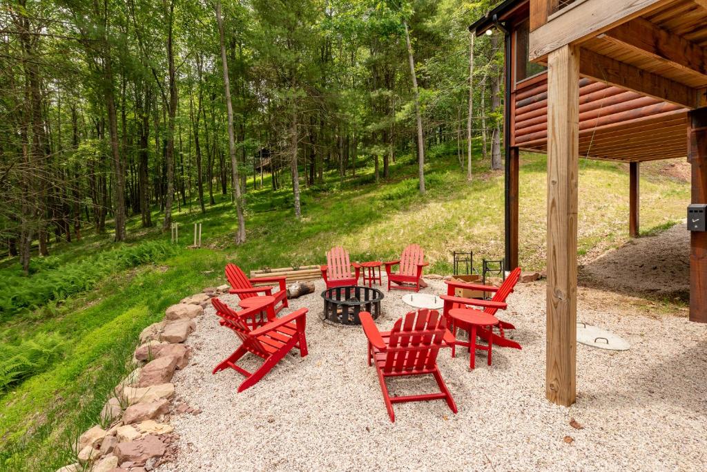a group of red chairs sitting around a fire pit at Lakefront Escape by Railey Vacations in Swanton