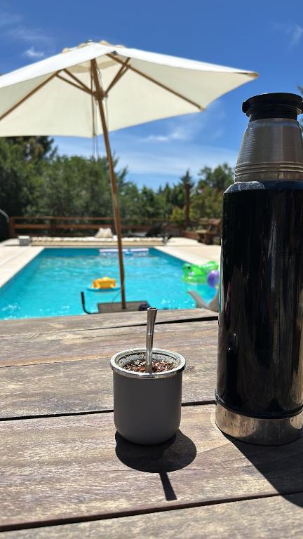 a drink in a cup on a table next to a pool at Altos del Cordón in Comodoro Rivadavia