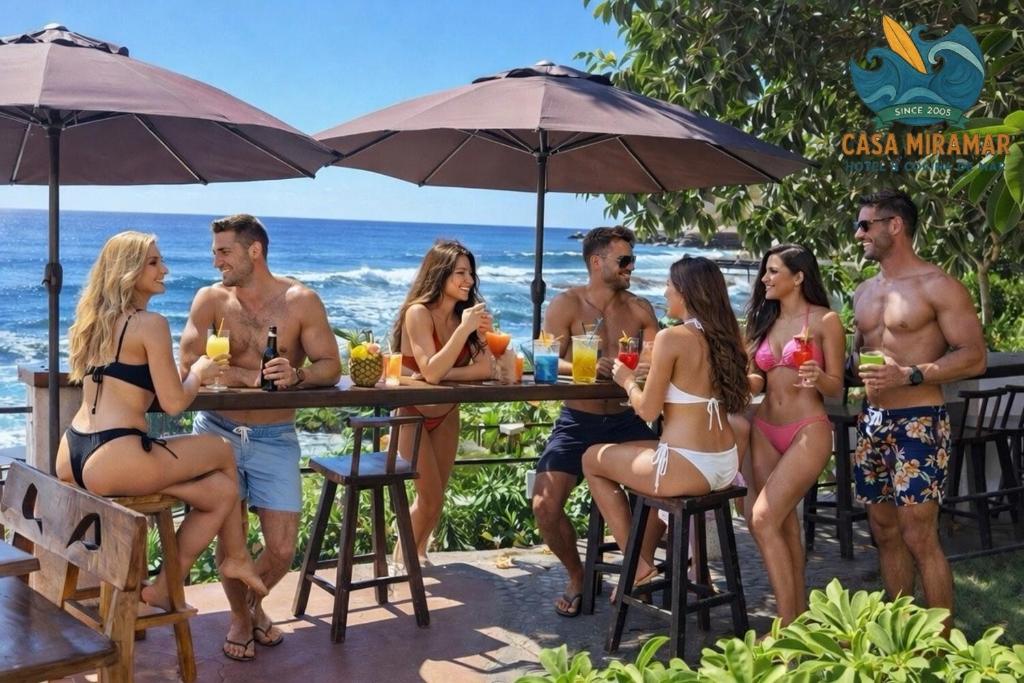 a group of people sitting at a table on the beach at Hotel Casa Miramar in Tamanique