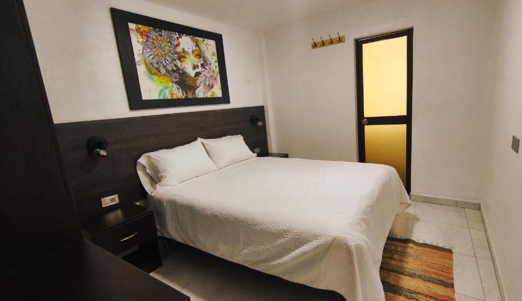 a bedroom with a bed and a painting on the wall at mini departamento Andahuaylas in Andahuaylas