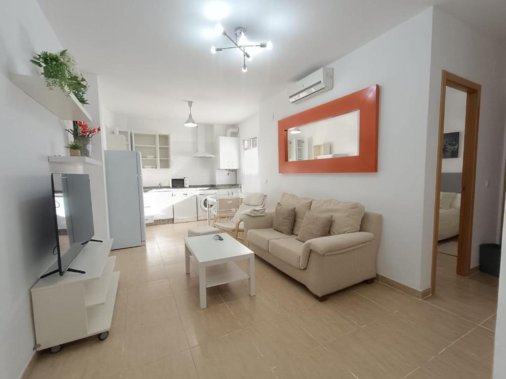 a living room with a couch and a tv at HOME CENTRO B max 5 personas HOME CENTRO A max 6 personas in Marchena