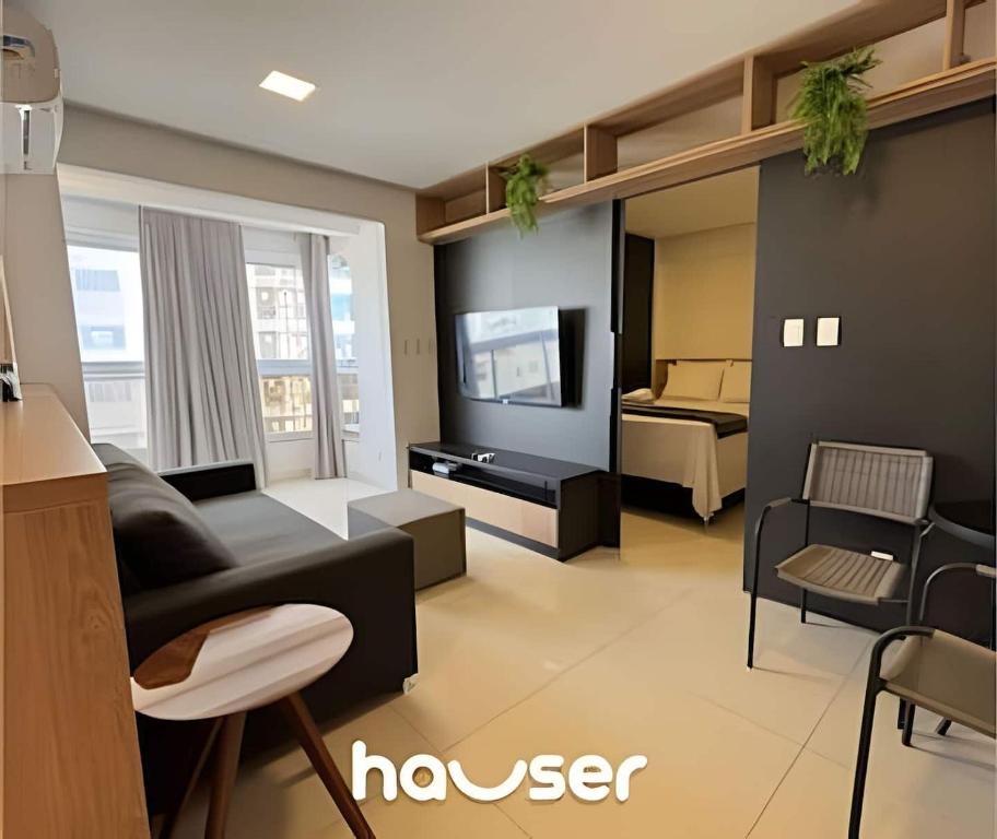 a living room with a couch and a television at Apart St Bueno Ar, Cozinha, Garagem Próx Órion in Goiânia