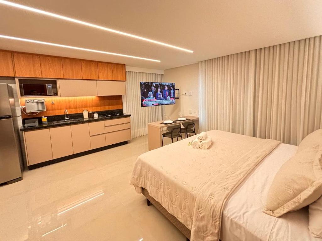 a hotel room with a bed and a kitchen at Apart St Bueno SuperKing Ar, Cozinha, Vaga in Goiânia