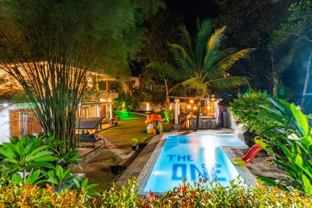 an image of a swimming pool in a garden at night at The One Hikkaduwa in Hikkaduwa
