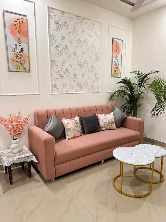 a living room with a pink couch and a table at Heartistry in Jabalpur