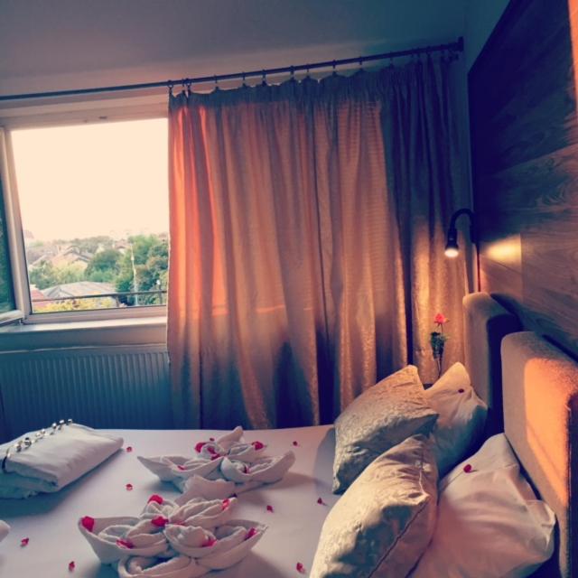 a bedroom with a bed with pillows and flowers on it at Double room H Požarevac in Požarevac