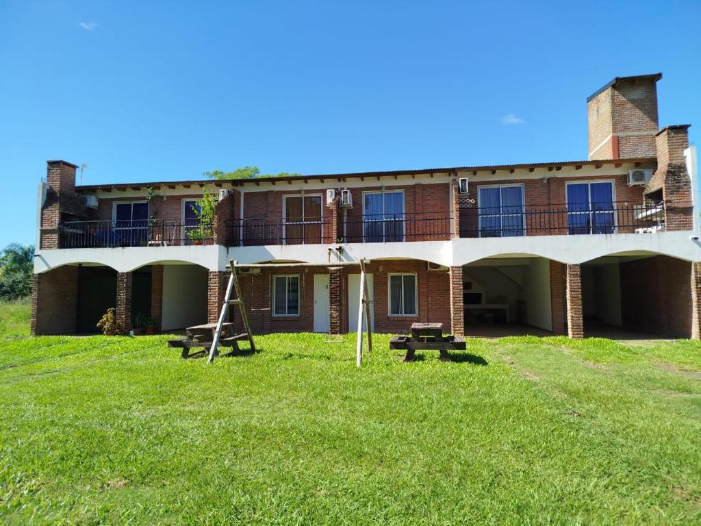 a large brick building with a grass field in front of it at Tu Destino in San José