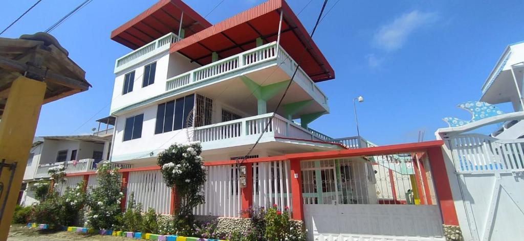 a tall white building with red trim at Suite Crucita in Crucita