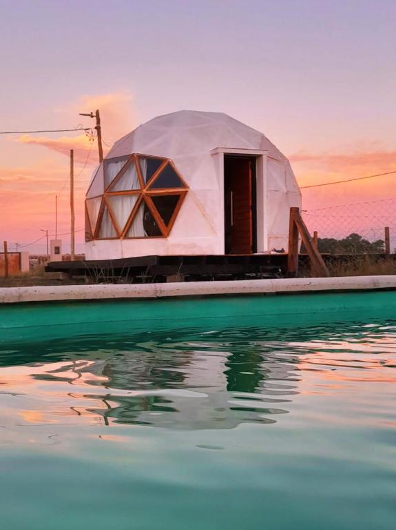 a dome tent on a dock next to a body of water at Glamping privado con pileta y quincho in San Vicente