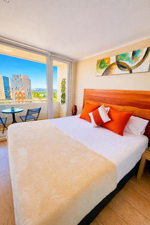 a bedroom with a large bed and a large window at DEPARTAMENTO ACOGEDOR Y TRANQUILO en Chillán Centro, full equipado, ideal para descansar, Wifi y Estacionamiento in Chillán