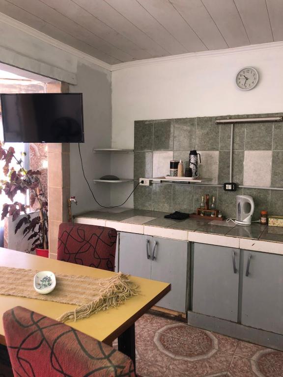 a kitchen with a table and a clock on the wall at ApartCarina in General Acha