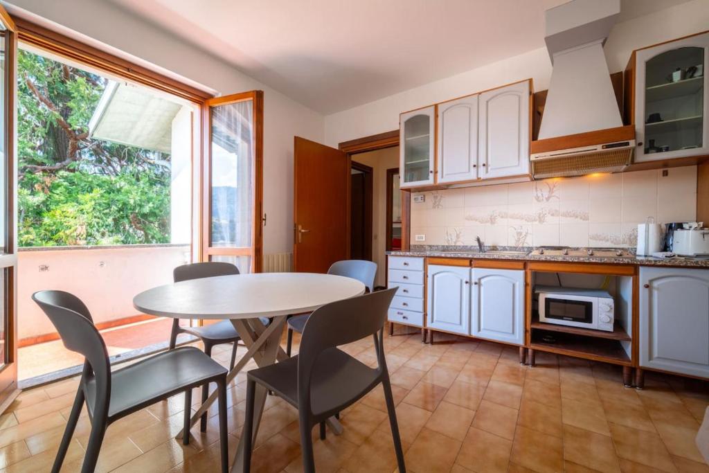 a kitchen with a table and chairs in a room at Primula Comfort Apartment in Bellagio