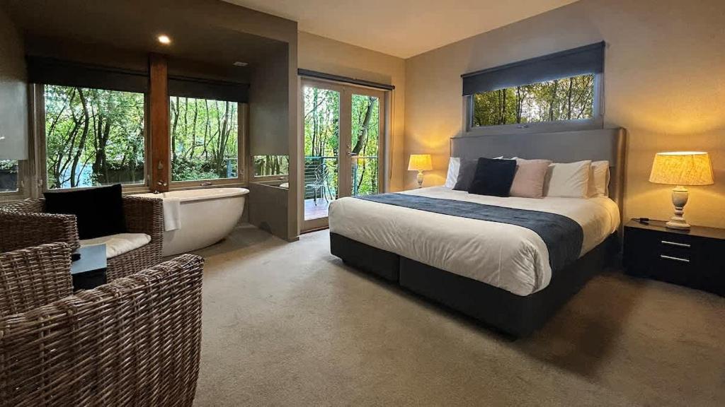 a bedroom with a bed and a bathroom with a tub at The Studio Suite at Villa 7 in Hepburn Springs