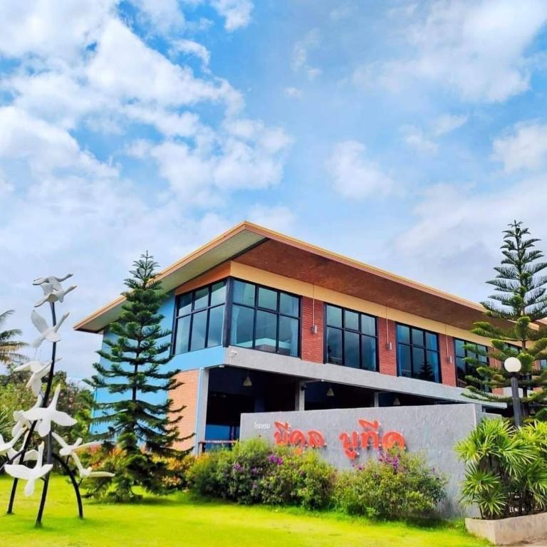 a large building with glass windows at โรงแรมบีคูลบูทีค in Ban Hua Phrong