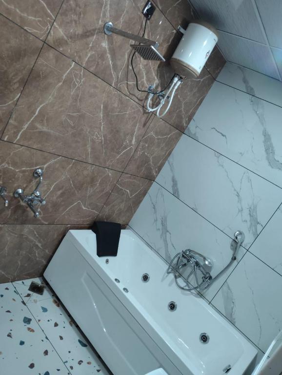 un baño con una bañera blanca y un lavabo en Hotel maya's, en Bāghpat