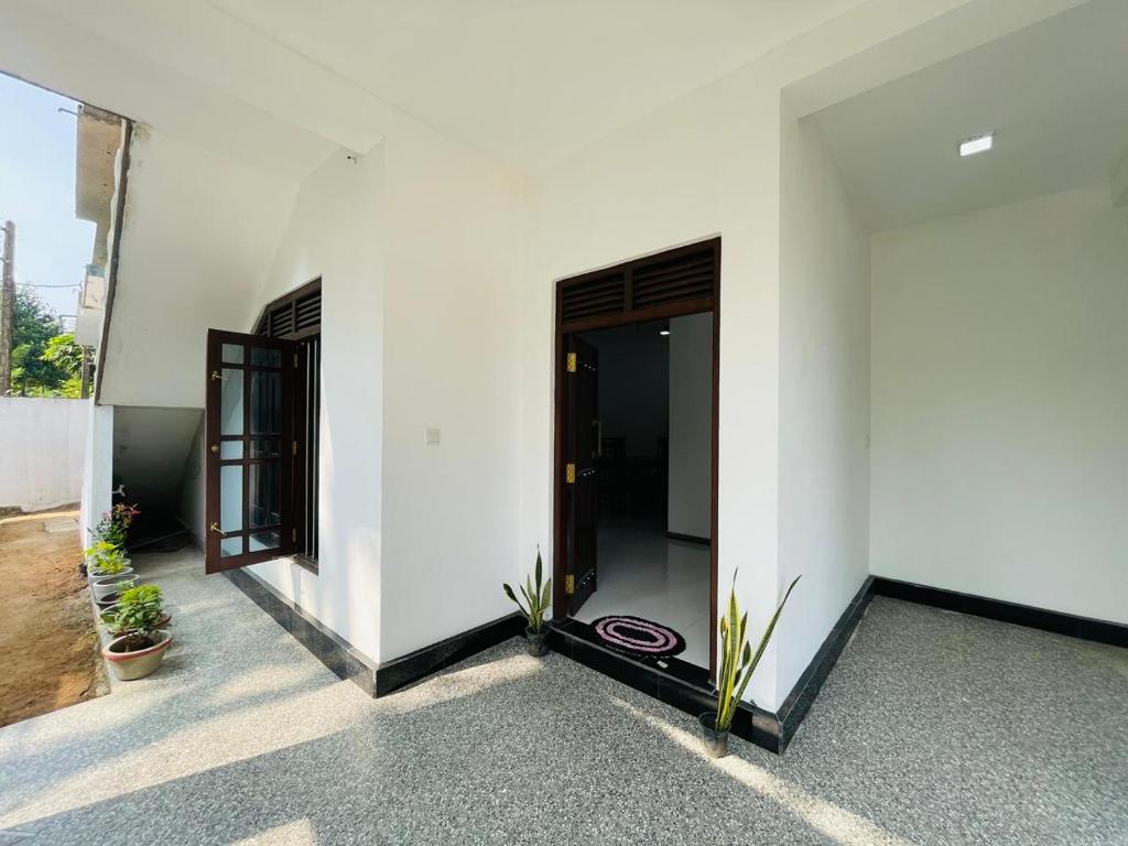 a hallway of a white building with a door at SH Villa in Weligama
