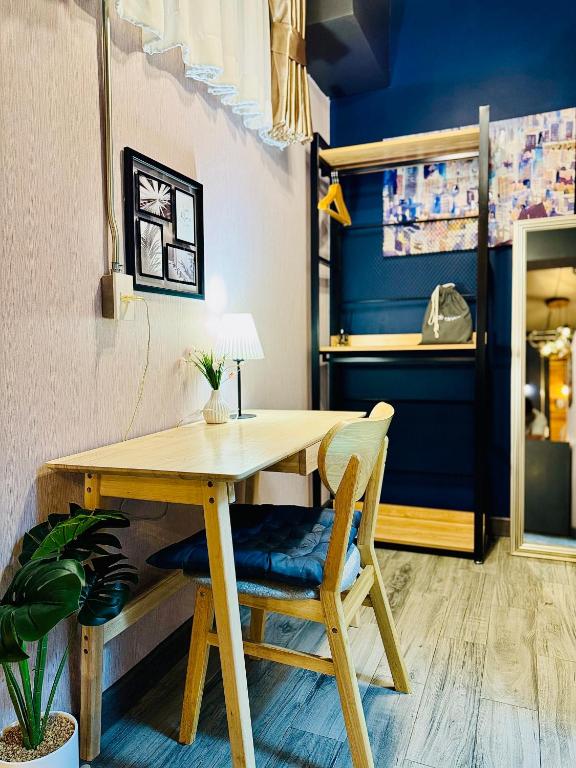 A small wooden desk and chair beside open wardrobe shelving.