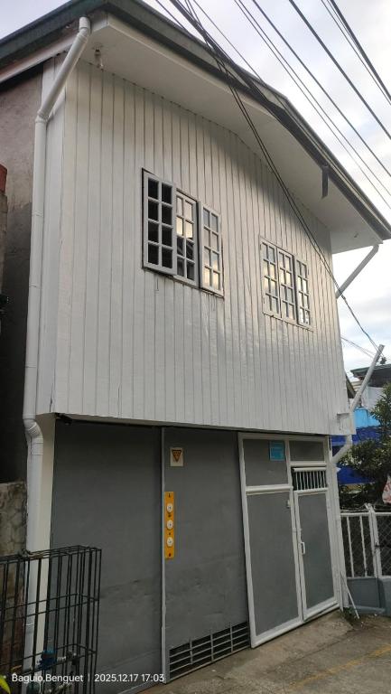 a house with two garage doors and two windows at Kochimoto Guesthouse in Baguio