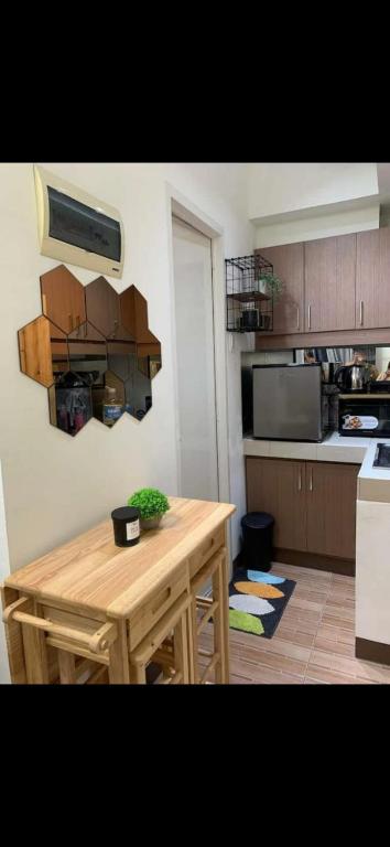 a kitchen with a wooden table in a kitchen at Essel s Comfy Place in Manila