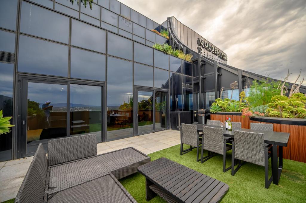 an exterior view of a building with tables and chairs at Sky One Grand Terrace Penthouse in Box Hill