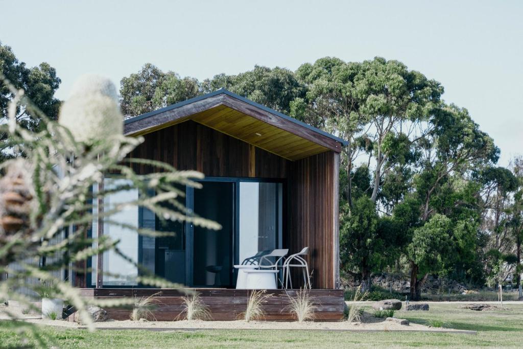 a small house with a window and a white chair in it at 3 Acres by the Moyne in Port Fairy